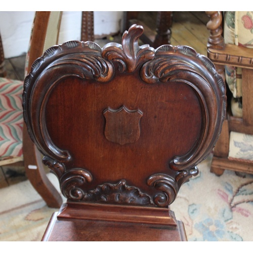 724 - A Victorian mahogany hall chair, the apple shaped back applied with 'C' scroll carving and centred w... 