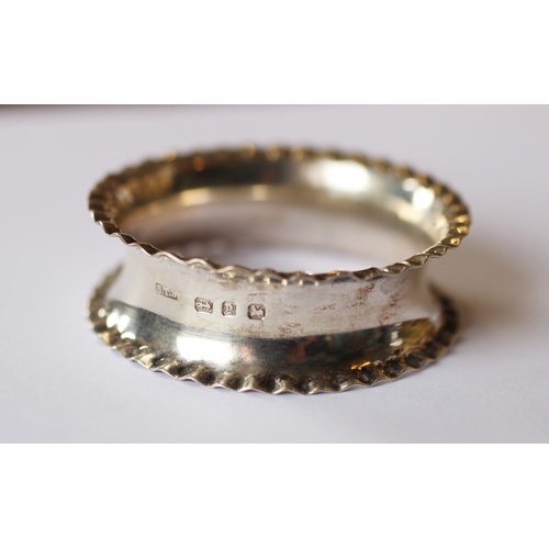 96 - A set of four silver napkin rings 'A & J E' Birmingham 1921, each with beaded rims, a further simila... 