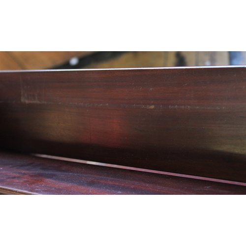 391 - An Edwardian, Regency style inlaid mahogany freestanding book trough, the trough above a single shel... 