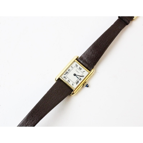 109 - A lady's gold plated Cartier Tank wristwatch, the rectangular cream dial with black Roman numerals, ... 