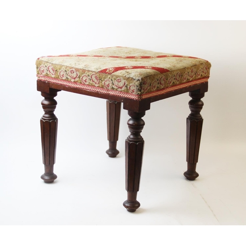 665 - A mid-19th century mahogany foot stool, the square needlepoint top supported by four tapered carved ... 