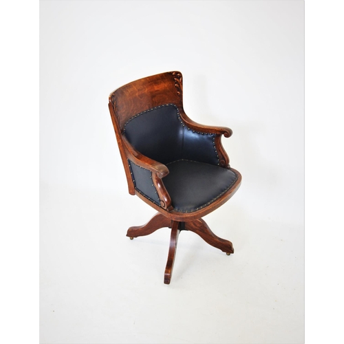 679 - A late 19th century oak adjustable desk chair, the concave back with carved leaf detail, above a pad... 