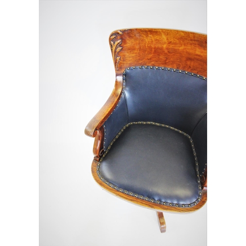 679 - A late 19th century oak adjustable desk chair, the concave back with carved leaf detail, above a pad... 