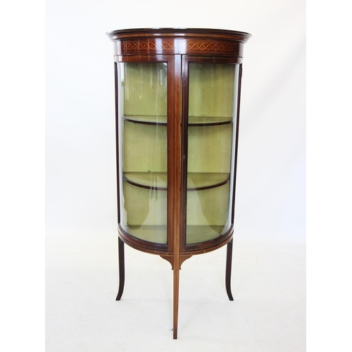 696 - An Edwardian mahogany demi-lune display cabinet, the frieze with trailing inlay above the single bow... 