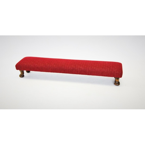 705 - A narrow footstool, mid 20th century, the red upholstered top raised upon stained beech wood squat c... 