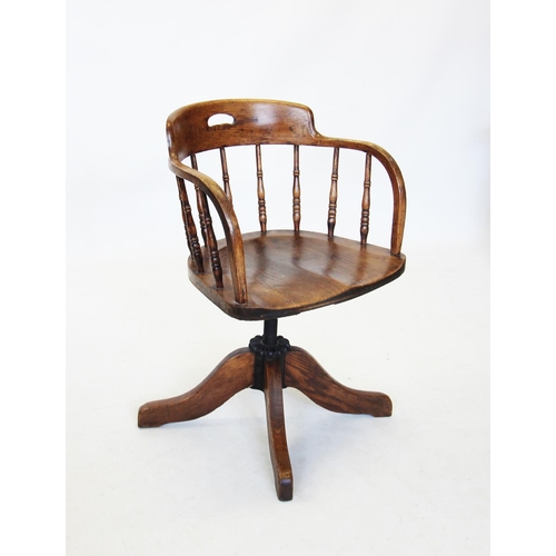 706 - An early 20th century oak revolving office chair, the down swept top rail raised upon slender turned... 