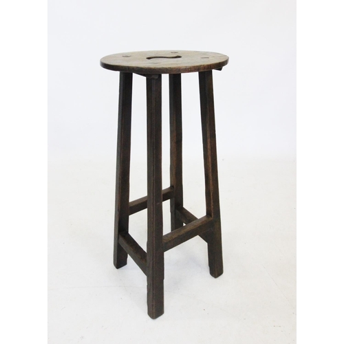 727 - An early 20th century oak clerks stool, the oval seat with an 'S' shaped aperture, raised upon chamf... 