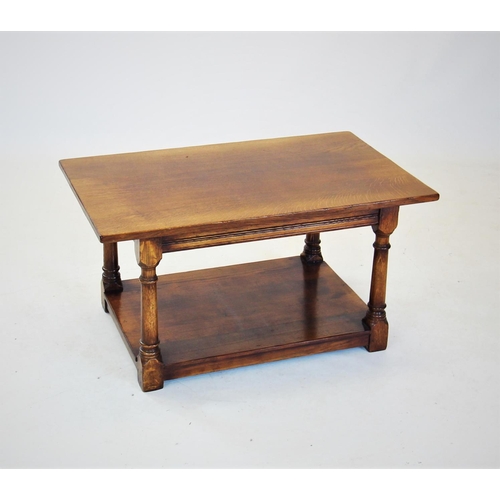 735 - A honey oak coffee table, late 20th century, the rectangular top raised upon turned tapering support... 