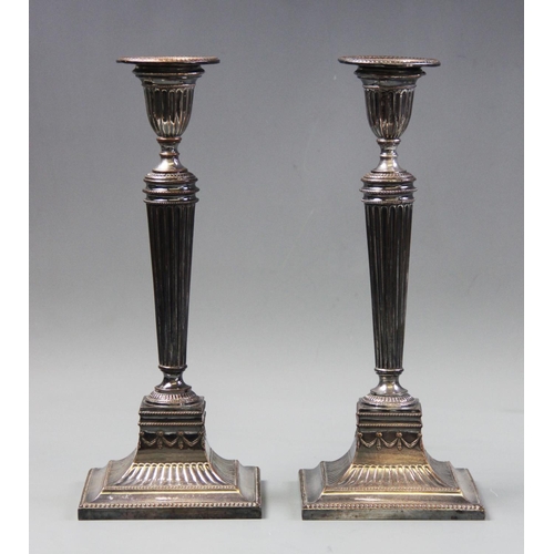 84 - A pair of old Sheffield plate candlesticks, of Neoclassical form with tapered fluted columns upon sq... 