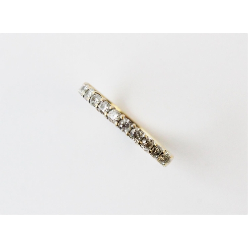 128 - A diamond half eternity ring, comprising eleven small round brilliant cut diamonds claw set in yello... 