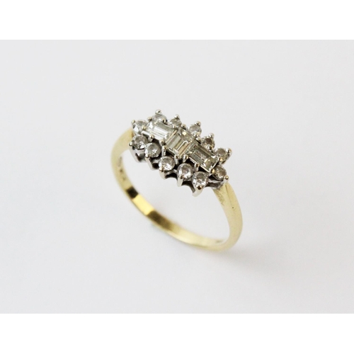 129 - A diamond cluster ring, comprising three rectangular step cut diamonds with a cluster surround of tw... 