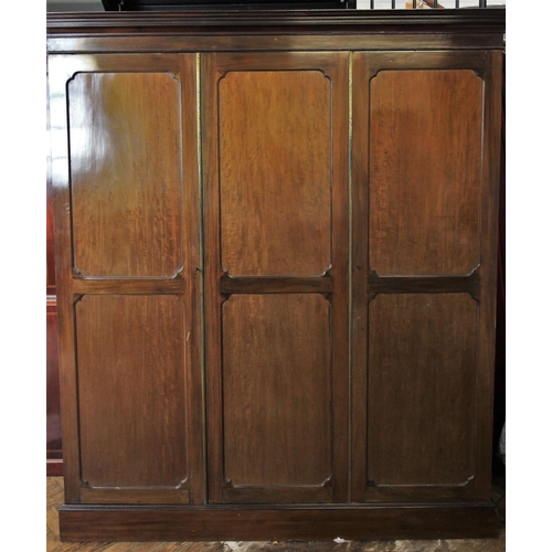 730 - An Edwardian mahogany two door wardrobe, the cavetto cornice above two outer invert panelled doors f... 