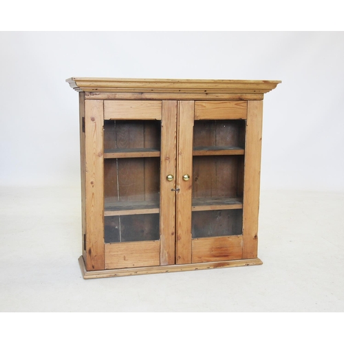 668 - A Victorian pine glazed wall cabinet, with a moulded cornice above two glazed doors enclosing three ... 