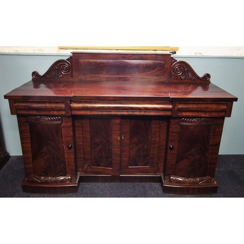 661 - A William IV mahogany inverted breakfront sideboard, the raised panel back with moulded scroll termi... 