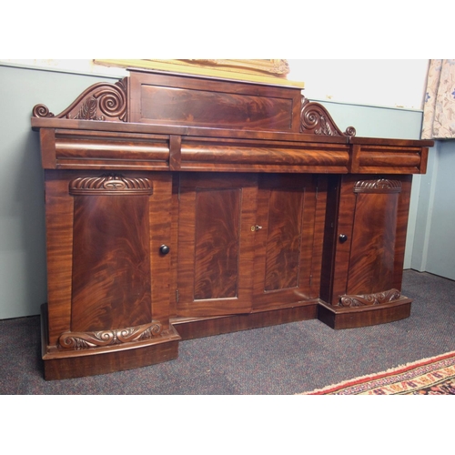 661 - A William IV mahogany inverted breakfront sideboard, the raised panel back with moulded scroll termi... 