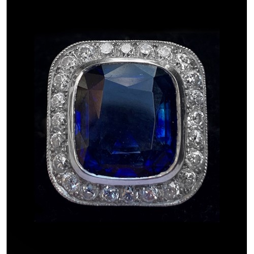 123 - A sapphire and diamond ring, the central cushion mixed cut sapphire with a border surround of twenty... 