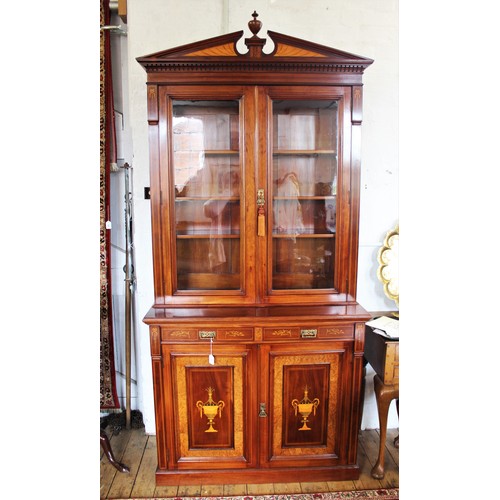 704 - An Edwardian Sheraton revival mahogany library bookcase, the architectural pediment inlaid with sati... 