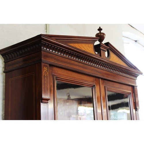 704 - An Edwardian Sheraton revival mahogany library bookcase, the architectural pediment inlaid with sati... 