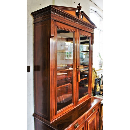 704 - An Edwardian Sheraton revival mahogany library bookcase, the architectural pediment inlaid with sati... 