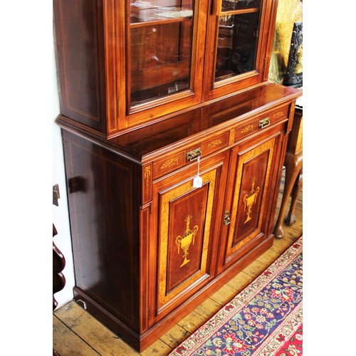 704 - An Edwardian Sheraton revival mahogany library bookcase, the architectural pediment inlaid with sati... 