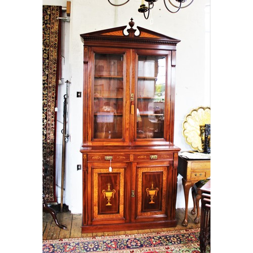 704 - An Edwardian Sheraton revival mahogany library bookcase, the architectural pediment inlaid with sati... 