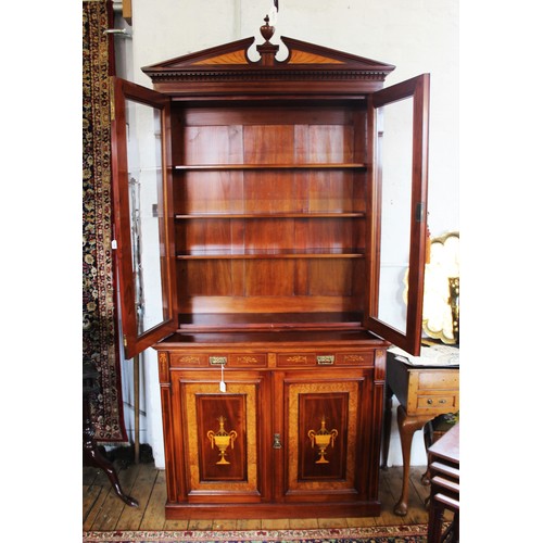 704 - An Edwardian Sheraton revival mahogany library bookcase, the architectural pediment inlaid with sati... 