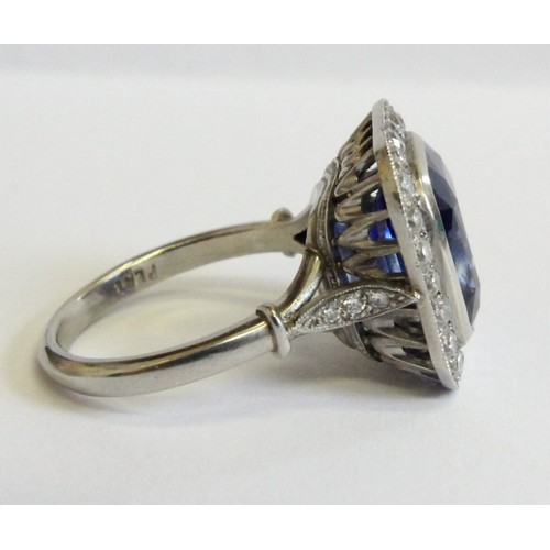 123 - A sapphire and diamond ring, the central cushion mixed cut sapphire with a border surround of twenty... 