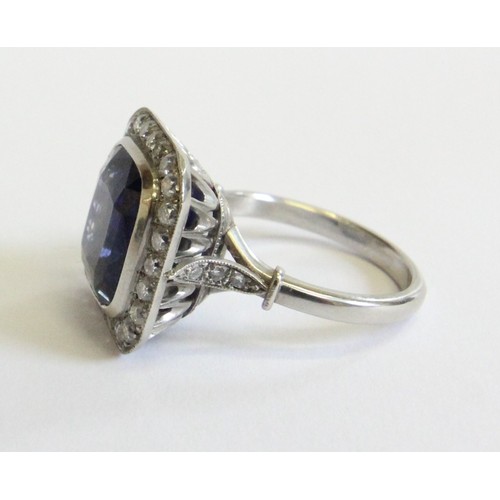 123 - A sapphire and diamond ring, the central cushion mixed cut sapphire with a border surround of twenty... 