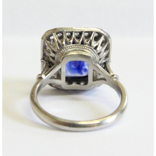 123 - A sapphire and diamond ring, the central cushion mixed cut sapphire with a border surround of twenty... 