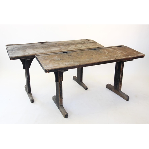 862 - A near pair of 19th century painted pine school desks, each with a sloping slab top carved with circ... 