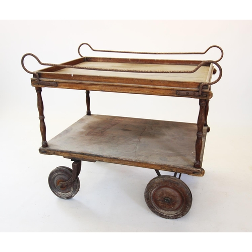 868 - A 19th century two tier serving trolley, the upper tray with iron side rails upon turned supports un... 