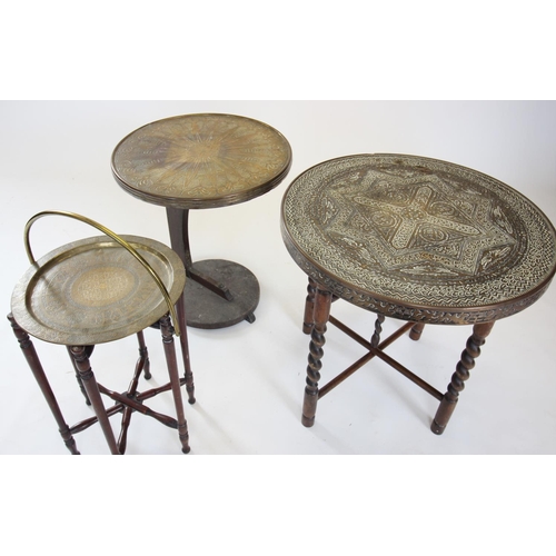 881 - An early 20th century Burmese brass top folding table, the circular embossed brass table top raised ... 