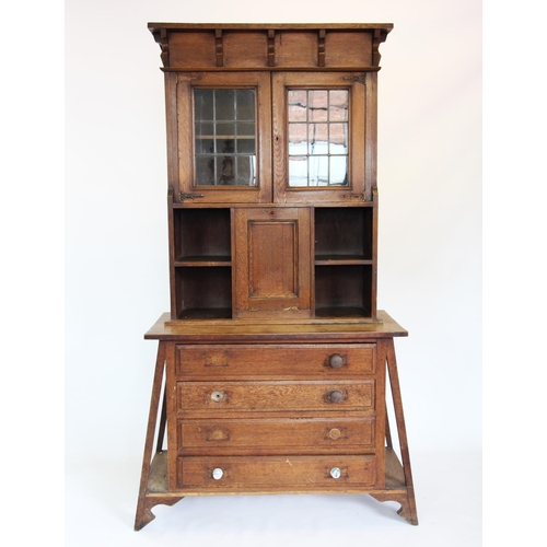 885 - A Glasgow school Arts and Crafts oak cabinet on chest, circa 1900, the hinged flat top and frieze co... 