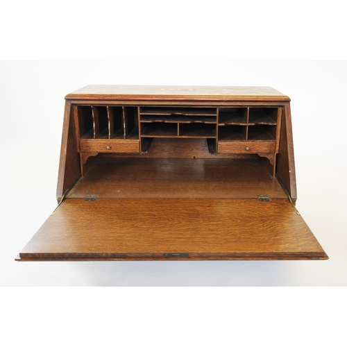 886 - An early 20th century oak stacking bureau, the fall front enclosing a compartmentalised interior, ab... 