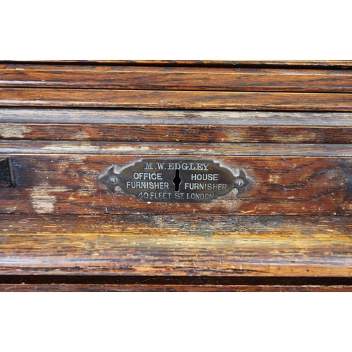 902 - An early 20th century oak roll top desk, the 'S' form tambour front enclosing a compartmentalised in... 