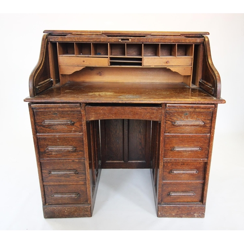 902 - An early 20th century oak roll top desk, the 'S' form tambour front enclosing a compartmentalised in... 