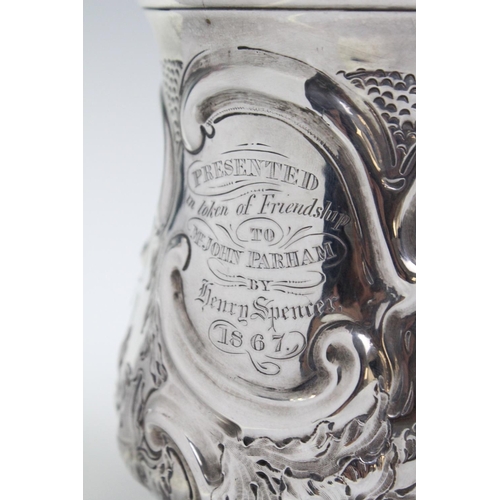 23 - A George III silver tankard, London 1819, of baluster form with embossed floral decoration and leaf ... 