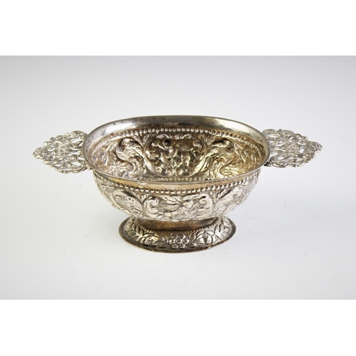 61 - A Dutch silver brandy bowl, of oval form with cast pierced handles on domed foot, elaborately emboss... 