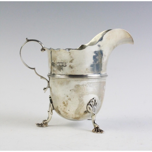 33 - A Victorian silver cream jug by Stokes & Ireland, London 1897, with shaped rim and scrolling handle ... 