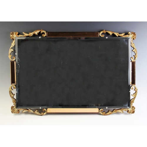 882 - A mid 20th century Art Deco wall mirror, the rectangular bevelled mirror framed by amber glass mirro... 