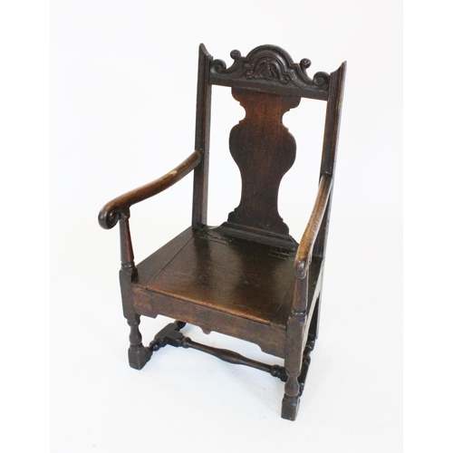 687 - A 17th century oak commode chair, the carved scrolling crest rail above a vase shaped splat and a hi... 