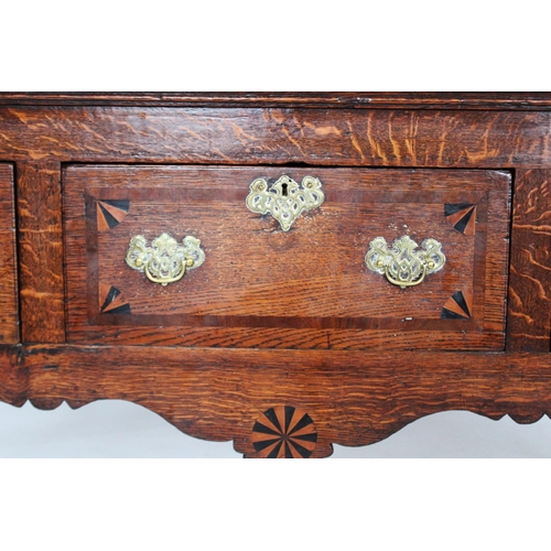 706 - A George III oak and mahogany cross banded dresser base, the rectangular cross banded top with round... 