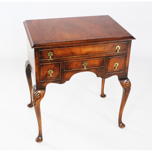 709 - A George II style walnut low boy, circa 1930, the rectangular cross banded top above an arrangement ... 