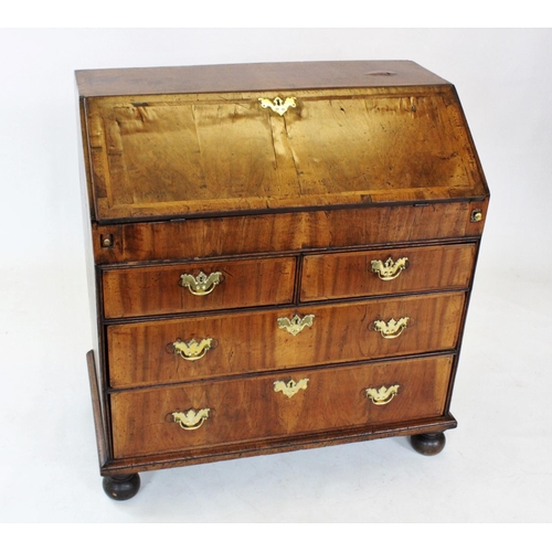 710 - A George II figured walnut bureau, the rectangular cross banded fall front enclosing an oak compartm... 