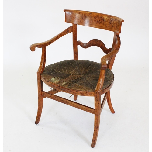 747 - An early 19th century Dutch fruit wood and marquetry elbow chair, the concave top rail inlaid with a... 