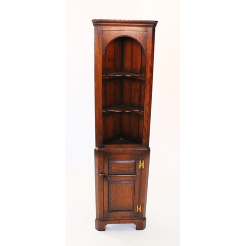 752 - A Titchmarsh & Goodwin freestanding oak corner cabinet, late 20th century, with an arched frieze abo... 