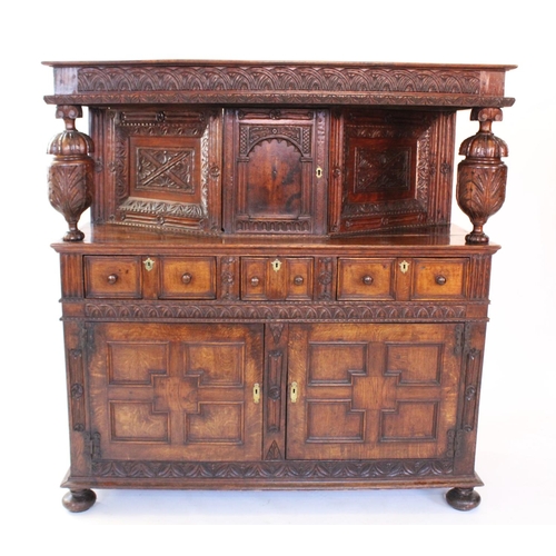 773 - A 17th century style oak court cupboard, late 19th century, profusely carved with a lunette frieze a... 