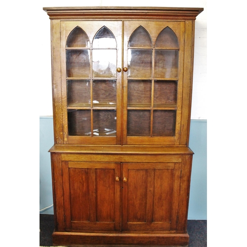 782 - A 19th century honey oak library bookcase, the moulded cornice above a pair of arcaded glazed doors ... 