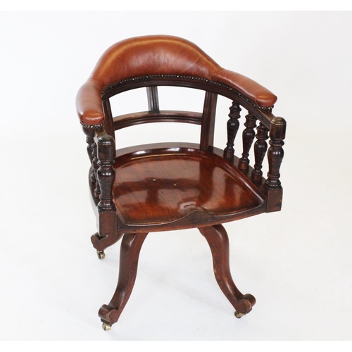 790 - An early 20th mahogany revolving desk chair, the padded leatherette top rail raised upon incised bal... 