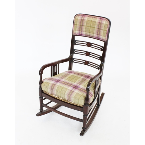 803 - An Edwardian mahogany rocking chair, with a padded back rest above a pierced ladder back and a ratta... 